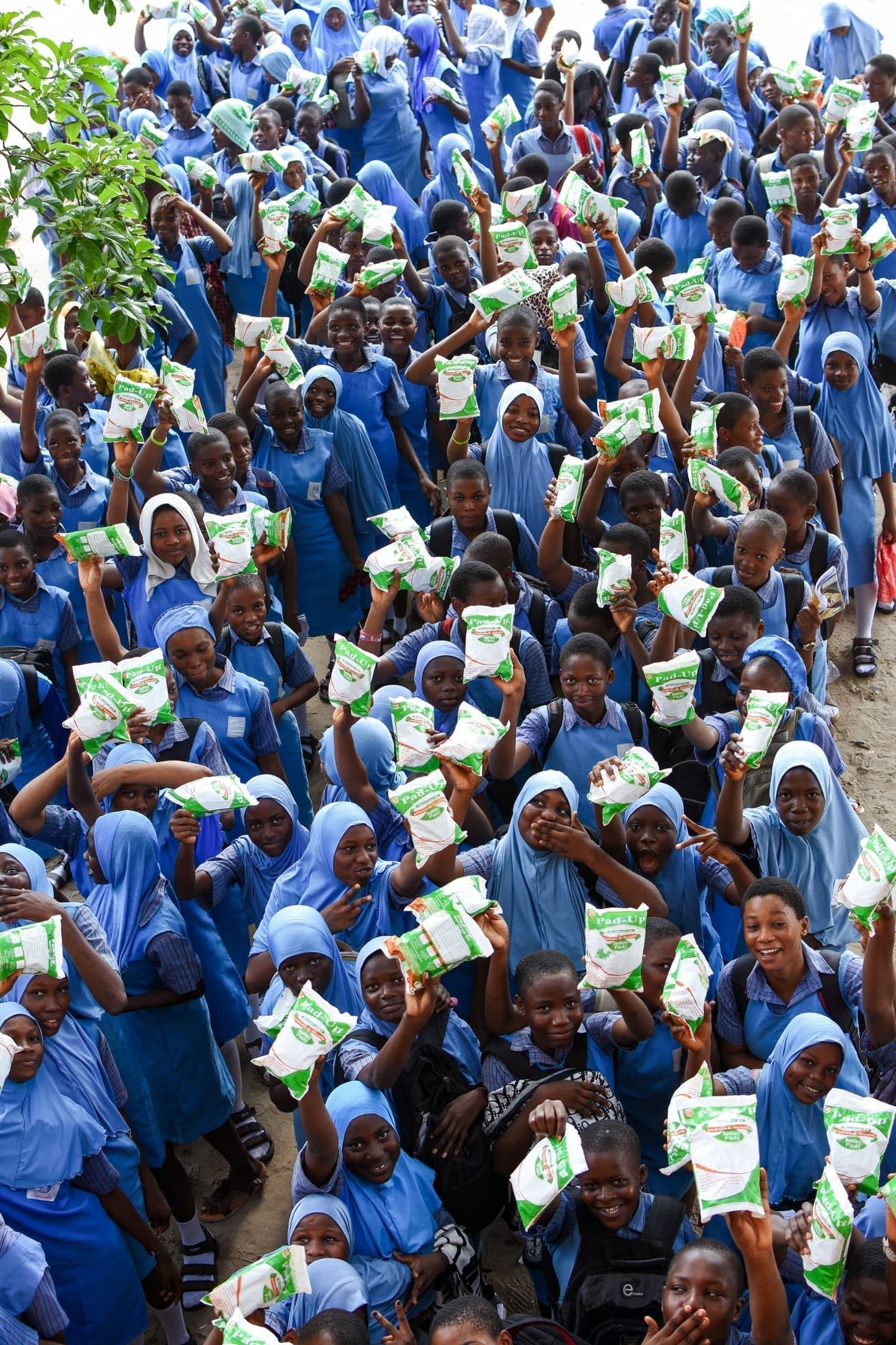 Schoolgirls holding up Pad-Up packs